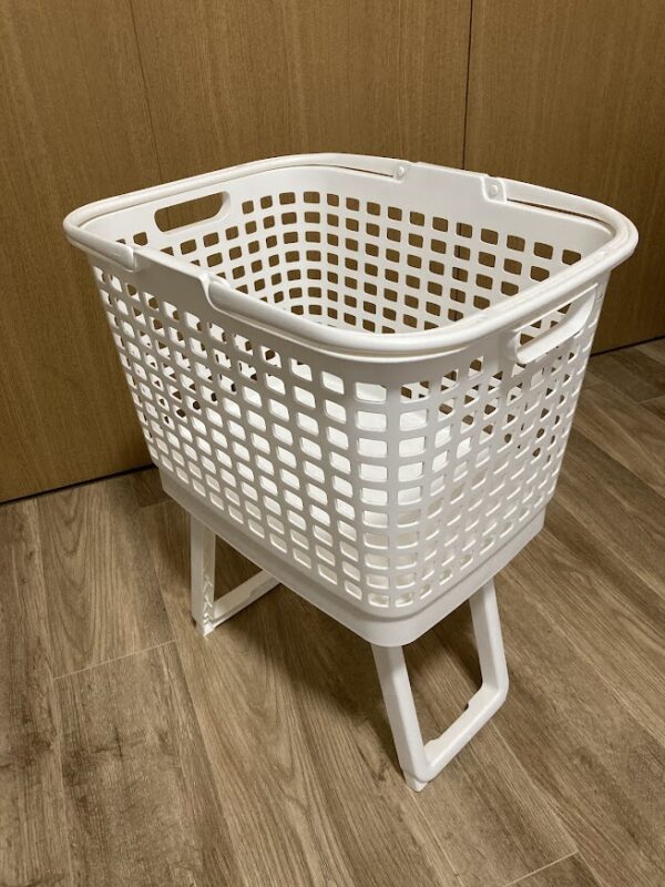脚を立てて高さを出したカインズの腰らくバスケット。しゃがまずに洗濯物を取り出せる様子。