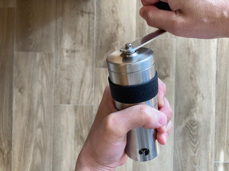 キャプテンスタッグのコーヒーミルを使い、手動で豆を挽いている様子。細身の本体が握りやすい。