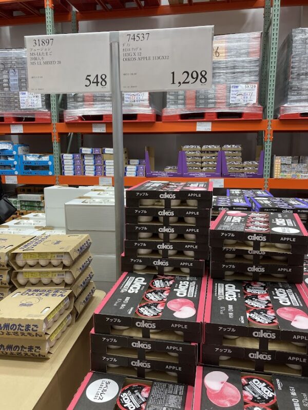 ストコのオイコス（12個入 1,298円）と、九州のたまご（20個入 548円）の売り場写真。全国最安値級の価格設定を証明する1枚。