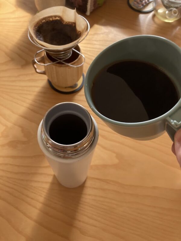 ドリップしたコーヒーをカップから象印のステンレスマグ水筒へ注いでいる様子