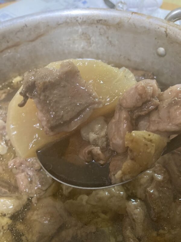 2日間煮込み、出汁が芯まで染みて飴色になった大根と、お玉の上でとろけるように柔らかくなった牛すじ