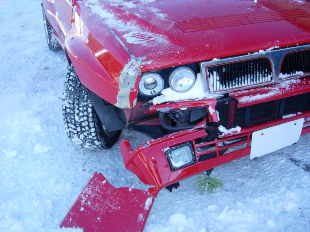 アイスバーンでスリップ事故を起こし、フロント部分が大きく大破した赤い乗用車
