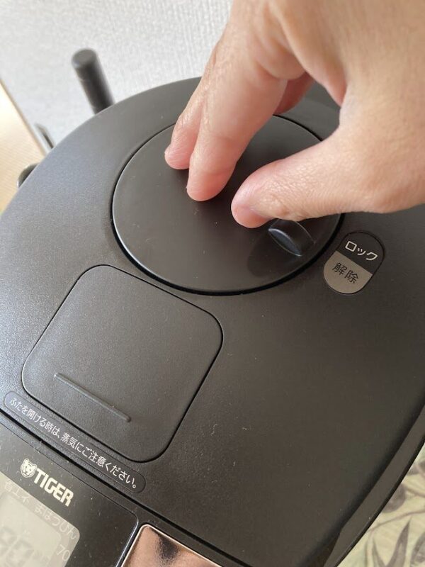 電気ポットのエアプッシュ式を触っている画像