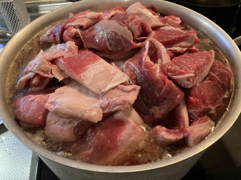 大根と牛筋の入った寸胴鍋におでんの素を溶かした水が、鍋ギリギリまで入れている画像。