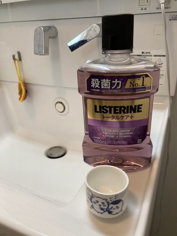 洗面台に置かれたリステリン トータルケアプラスと、ちいかわのキャラクターが描かれたおちょこ