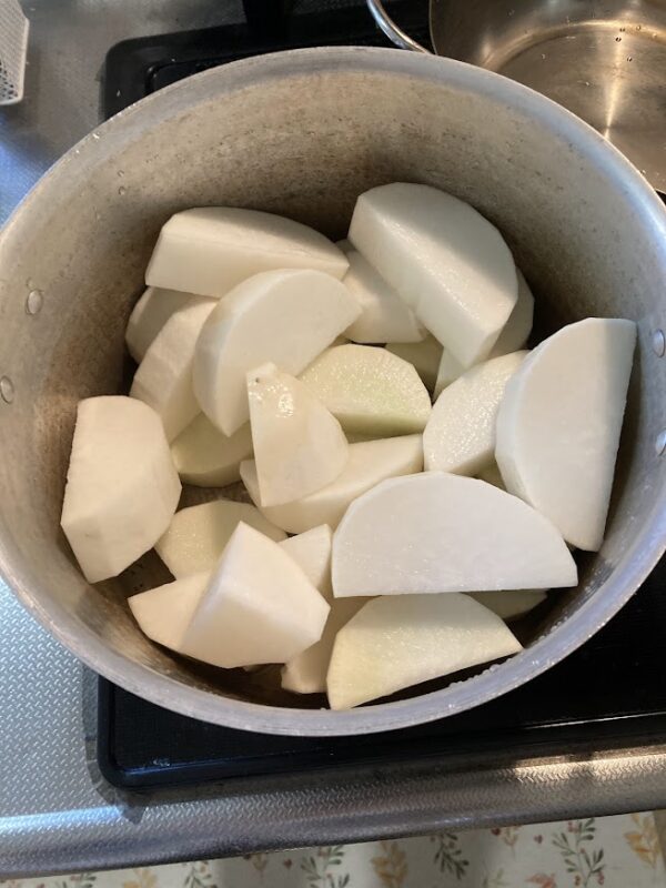 アルミ鍋いっぱいに敷き詰められた、厚切りの大根