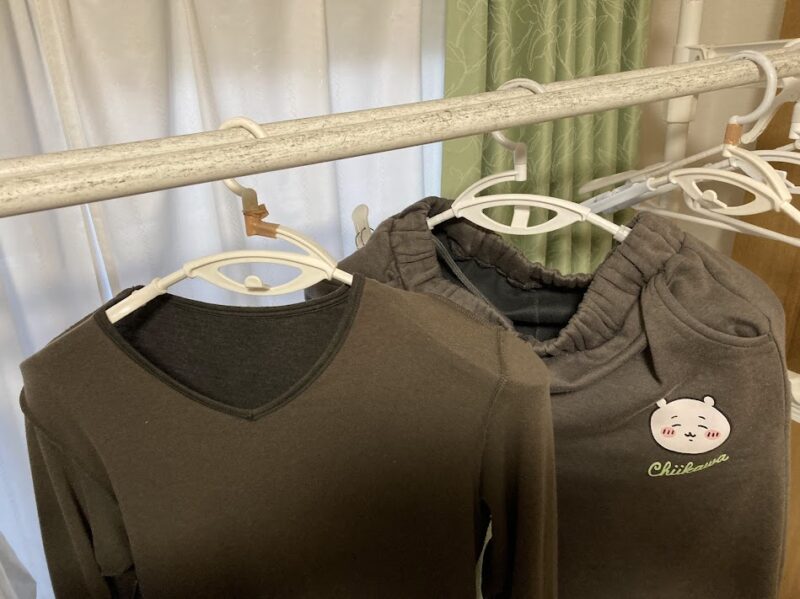 ニトリの衣類が乾きやすいハンガーで脇の下に隙間を作り、部屋干しの生乾きを防いでいる様子。