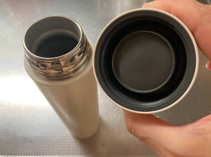 キッチンのシンク横で、象印シームレス栓の蓋の裏側を見せている写真。パッキンが一体化しており、溝が少なく洗いやすい構造がはっきりと確認できる。