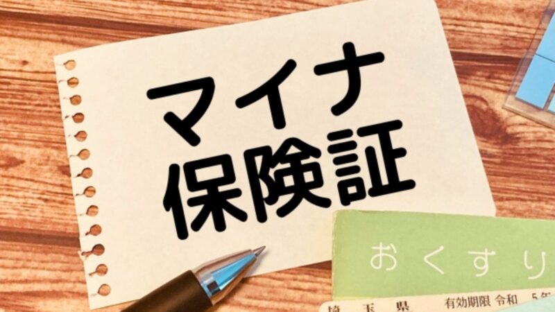 「マイナ保険証」と書かれたノート、ペン、お薬手帳が並んだイメージ画像。保険証の空白期間でも、資格情報のお知らせがあれば受診できることをまとめる冒頭。