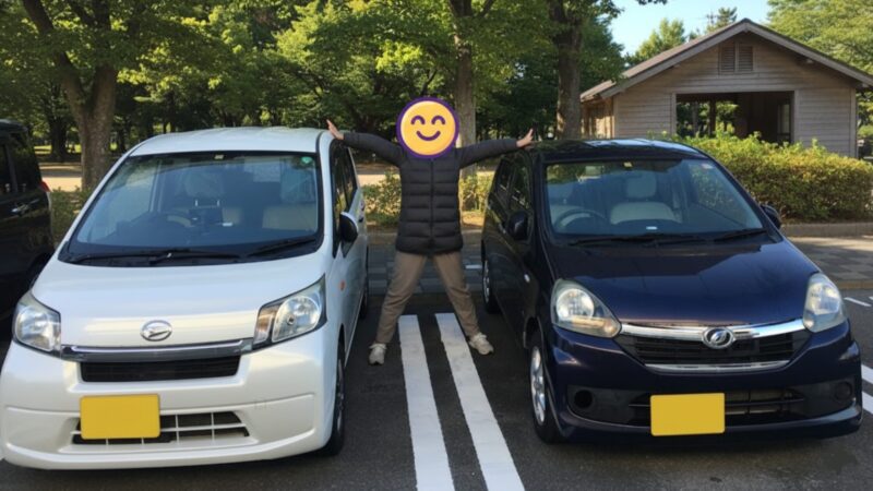 駐車場に並ぶパールホワイトのダイハツ・ムーヴと、紺色の軽自動車。その間に立つ人物が両方の車に手を添える、はちぽ夫婦のカーライフを象徴する日常の1枚。
