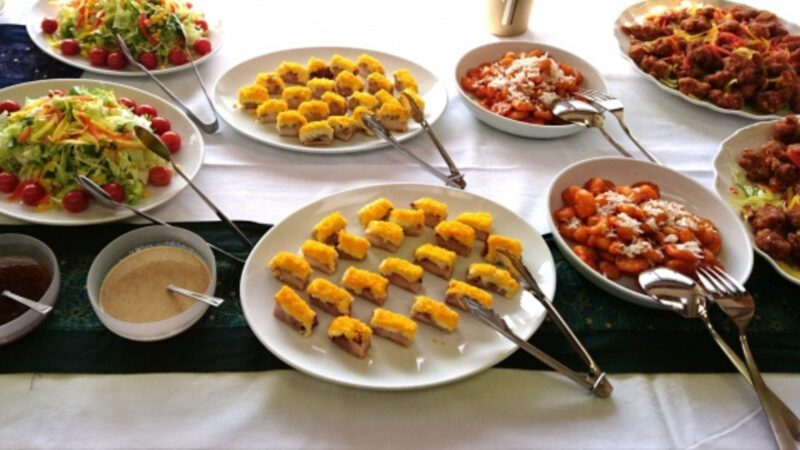 ホテルのバイキング会場に並ぶサラダや揚げ物など種類豊富な料理のイメージ画像