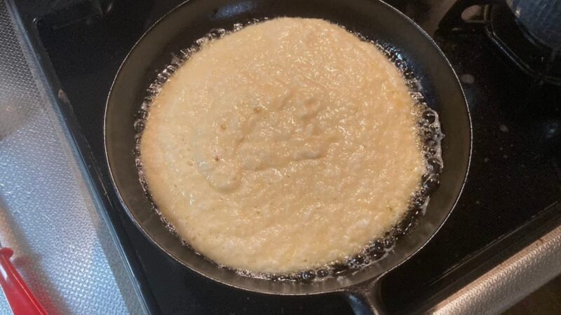 岩鋳の鉄板に流し込まれ、じっくりと焼き上げられている山芋鉄板の生地