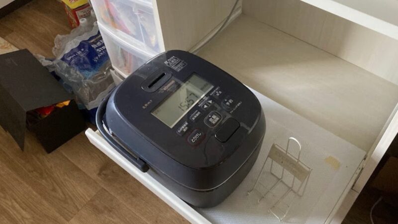 ニトリの食器棚にあるスライド式炊飯器置き場を手前に引き出した状態の写真。5年以上日常的に引き出したまま使用しても歪みや劣化がなくしっかり支えられている様子。