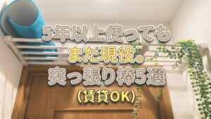「5年以上使っても まだ現役。 突っ張り棒5選(賃貸OK)」という文字が入ったアイキャッチ画像。背景は実際のトイレのドア上に設置された突っ張り棚の日常風景で、青いマットとグリーンネックレスが飾られている。