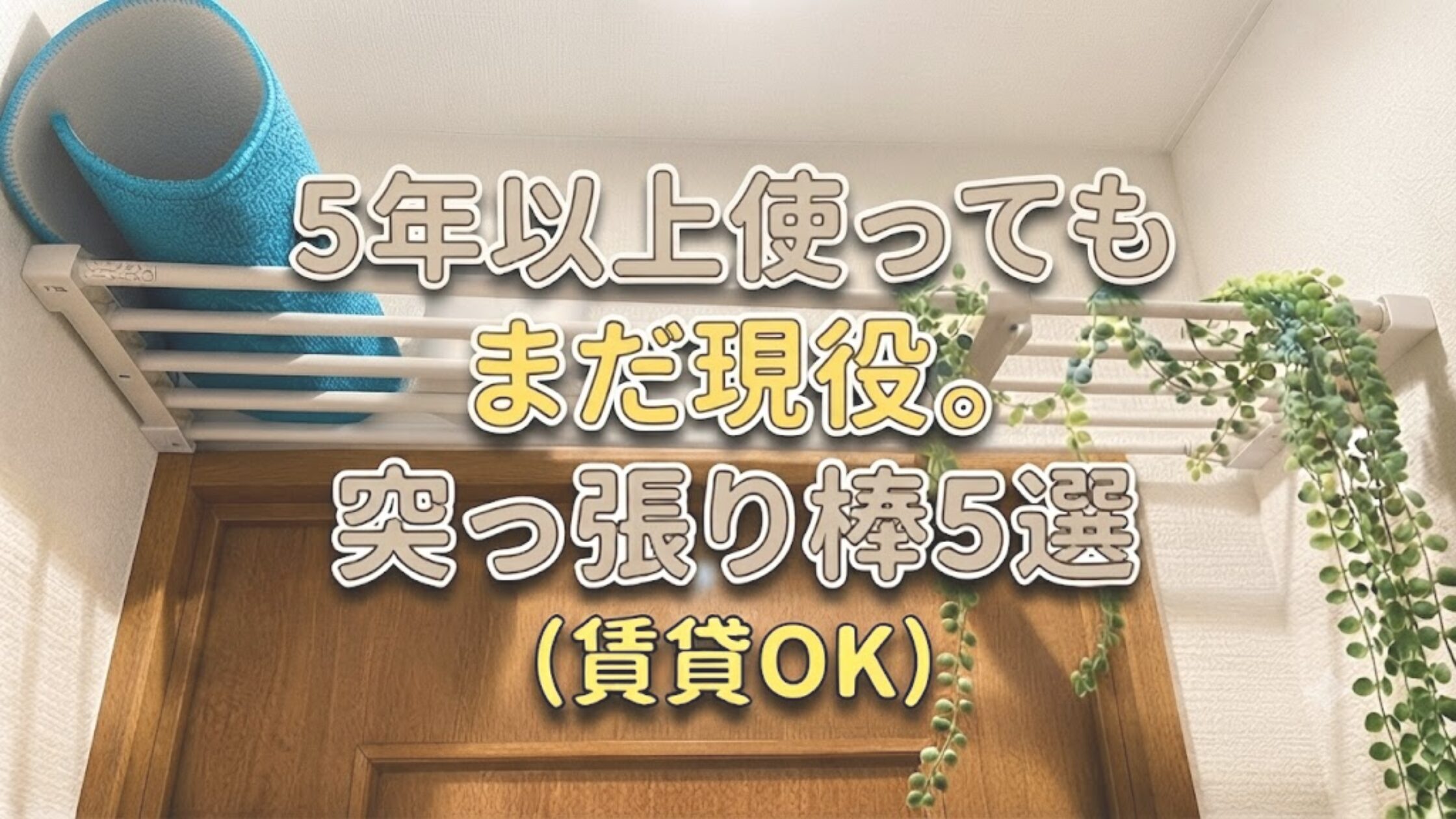 「5年以上使っても まだ現役。 突っ張り棒5選(賃貸OK)」という文字が入ったアイキャッチ画像。背景は実際のトイレのドア上に設置された突っ張り棚の日常風景で、青いマットとグリーンネックレスが飾られている。