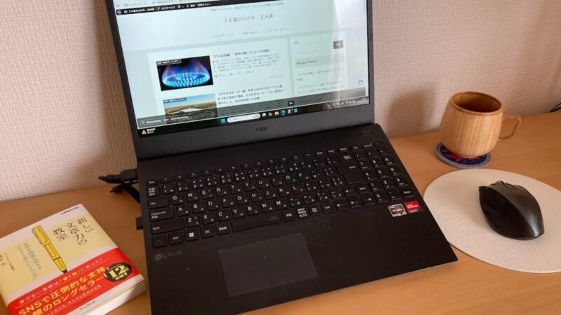 38歳からの半・主夫道ブログの運営報告に使用している、ノートPCとコーヒーカップが置かれたデスクの作業風景