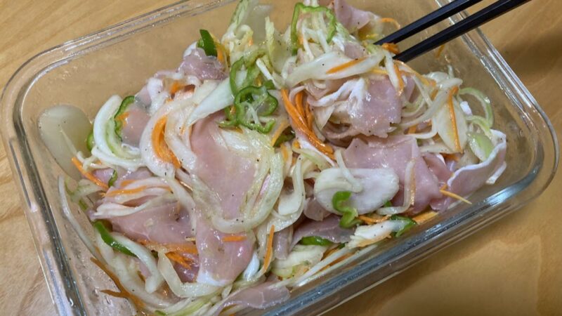 一晩冷蔵庫で寝かせ、野菜がしんなりと生ハムに馴染んだ2日目の生ハムマリネ。味が染み込んでいる様子がわかるガラス容器に入った写真。