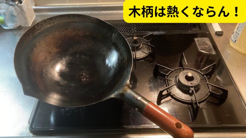 コンロの上に置いた中華鍋と「木柄は熱くならん！」という文字が入った解説画像