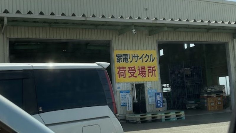 指定引取場所(運搬会社倉庫)にある「家電リサイクル 荷受場所」と大きく書かれた黄色い看板と荷降ろしスペースの写真