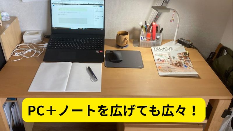 カリモクデスクの上にノートパソコンやノート、文房具を広げた広々とした作業スペース写真