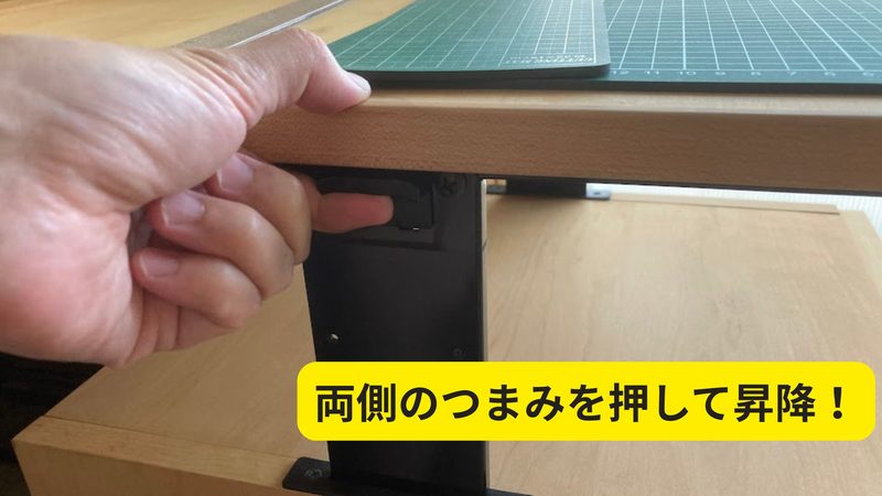 カリモク昇降ワゴンの天板高さを調整する両側つまみレバーの操作イメージ写真