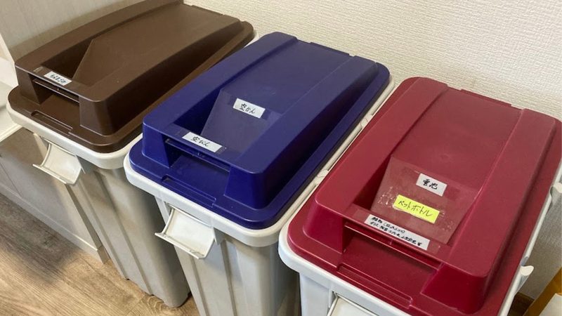 茶色・青・赤の蓋がついたナフコの連結ゴミ箱が3つ並んでいる様子。「もえるごみ」「空かん」「ペットボトル」のラベルが貼られている