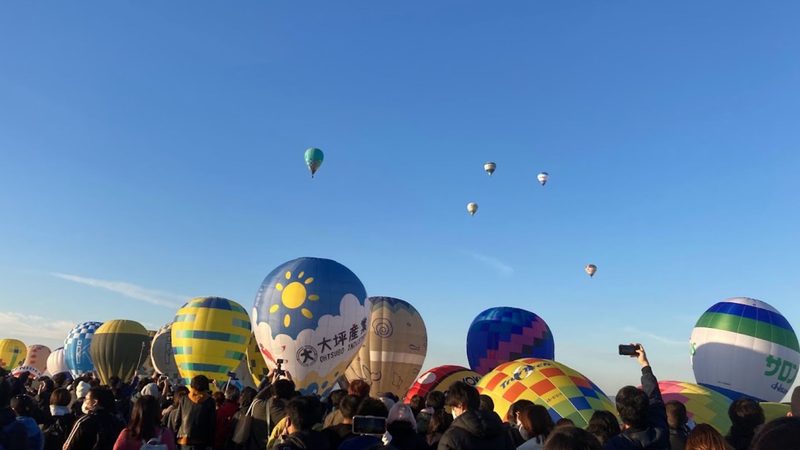 佐賀バルーンフェスタで一斉離陸を待つ観客と、離陸前に膨らんだ熱気球