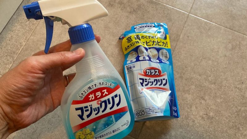 ガラスマジックリンの本体ボトルを手に持った写真と、後ろに添えられたつめかえ用パウチ