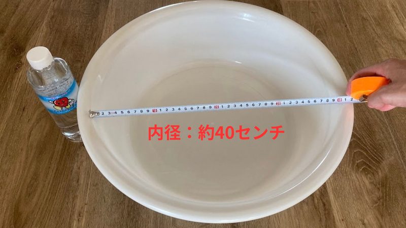 内径約40cmの大きなプラスチック製タライのサイズ感をペットボトルとメジャーで測って比較している写真